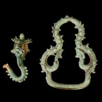 Image of two jewelry items, a hook and a ring against a black backdrop